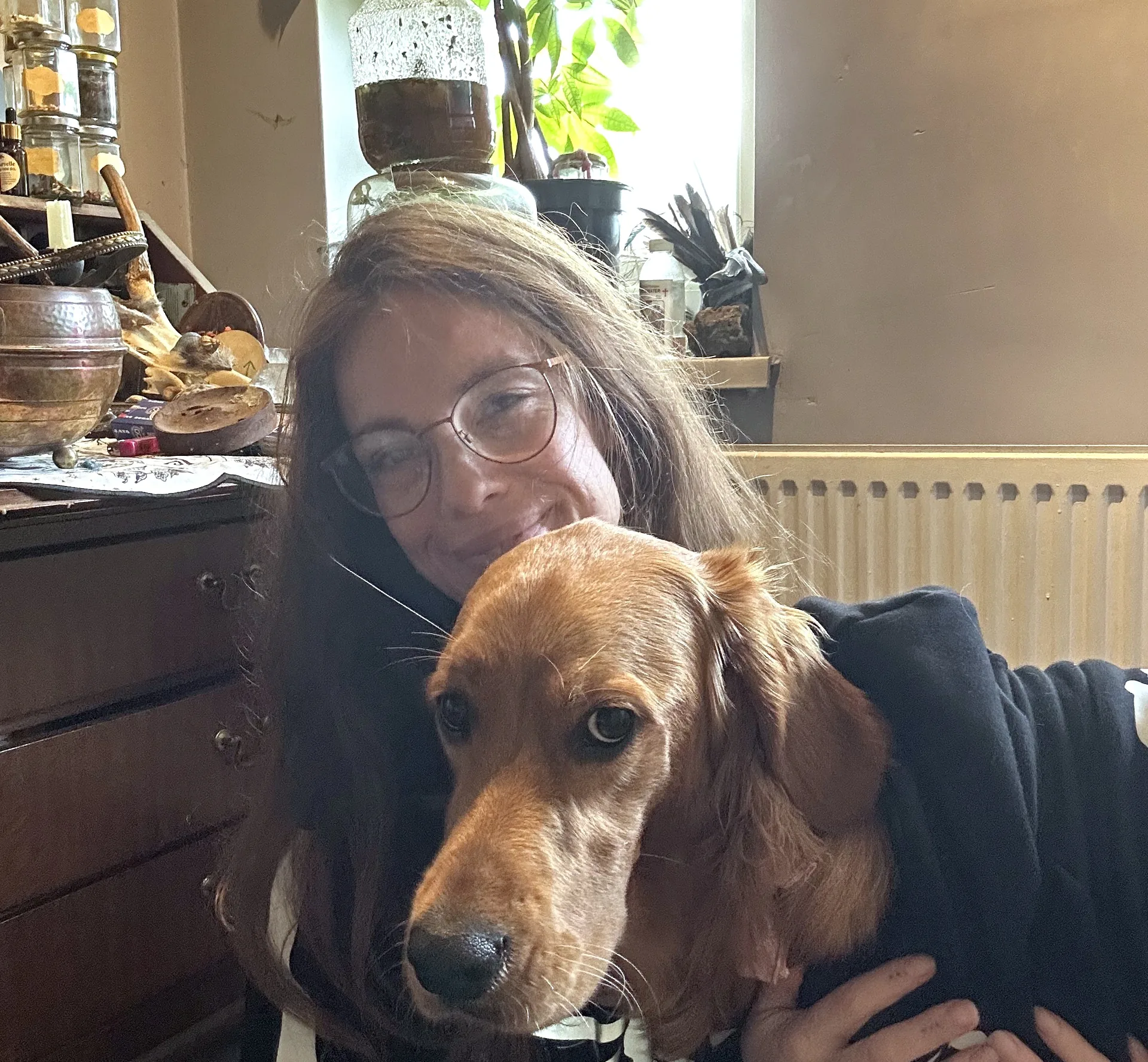 Jasmine at home, smiling, with her dog Hazel in her arms